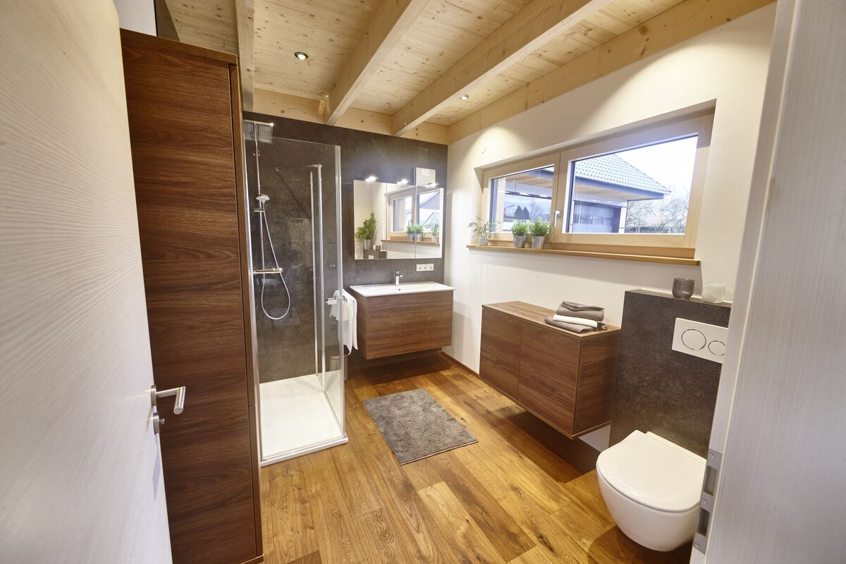 Bad mit ebenerdiger Dusche, Holzboden und Waschtisch aus Massivholz