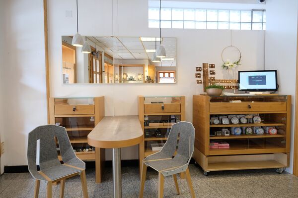 Ladeneinrichtung aus Holz mit Warentischen, Regalen und Beratungsplatz