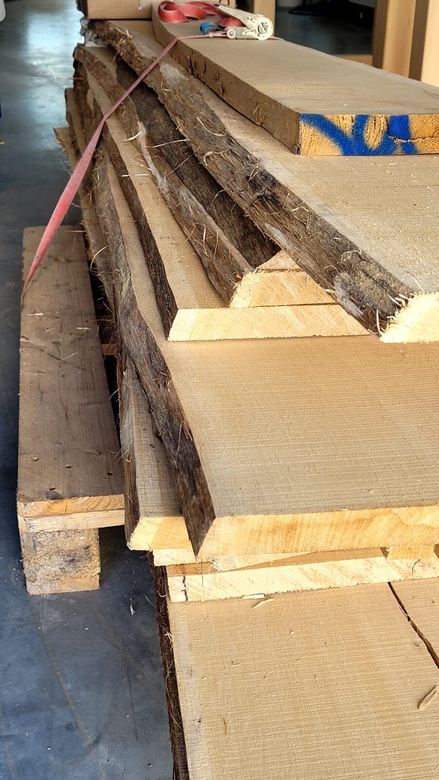 Stapel gesägter Bohlen mit sichtbarer Maserung im Holzlager