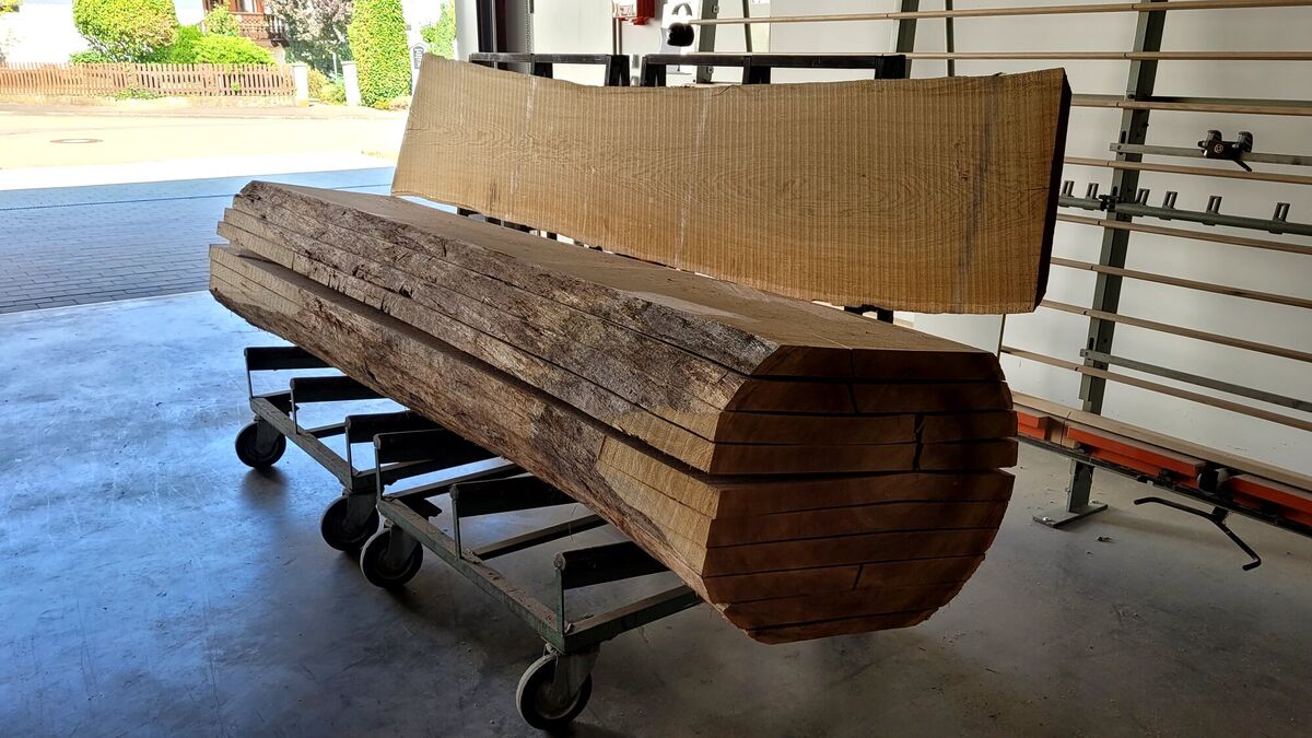 Massivholz-Bohle mit Baumkante auf dem Rollwagen in der Werkstatt