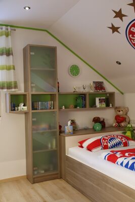 Vitrine mit Glastüren neben dem Bett im Jugendzimmer